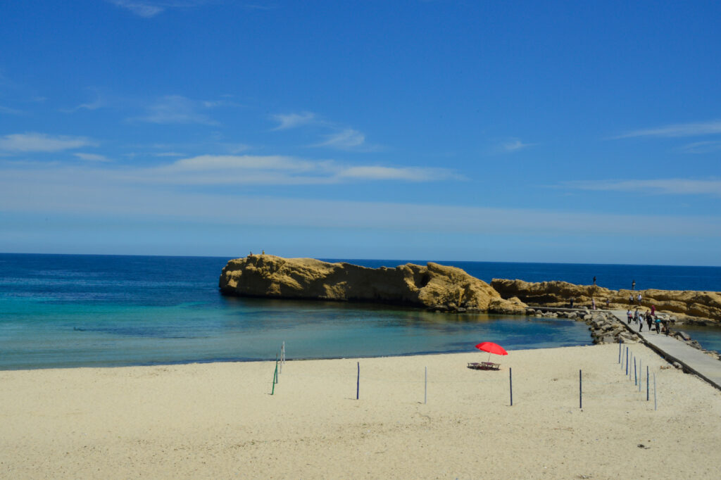 Beach mit rotem Sonnenschirm